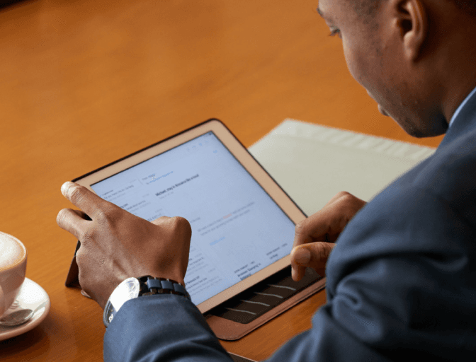 A man reads an email document on a tablet. 