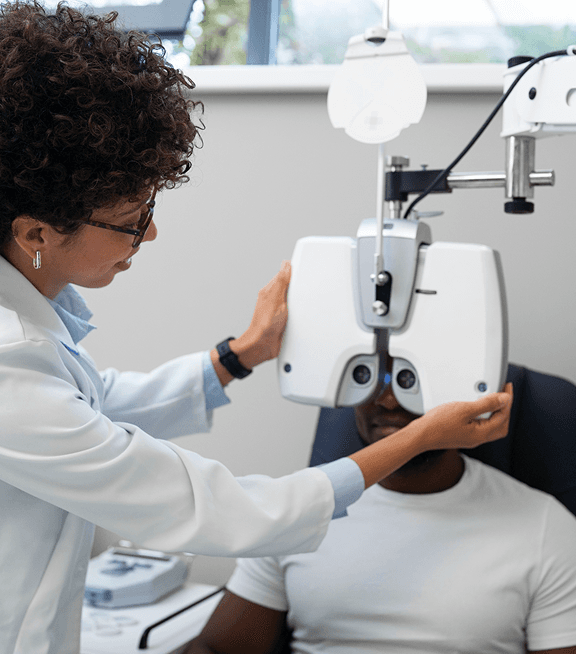 A female optometrist tests the vision of a seated patient.